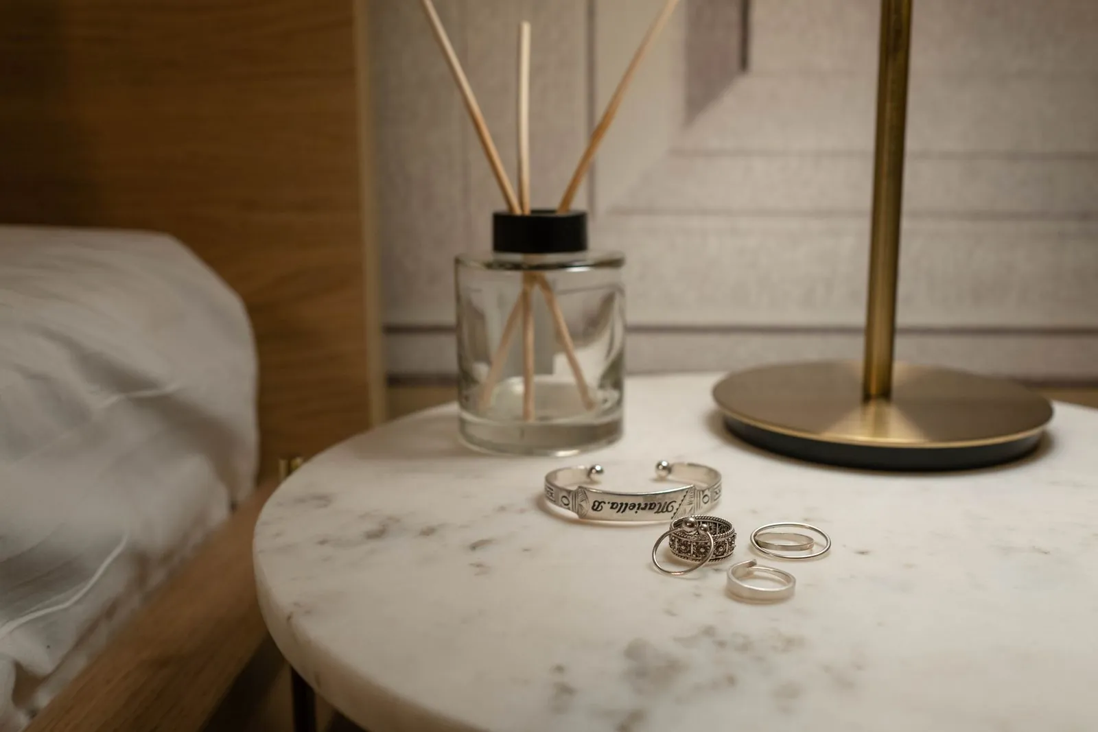Alianzas y pulsera sobre una mesita de noche de mármol, divorcio sin hijos