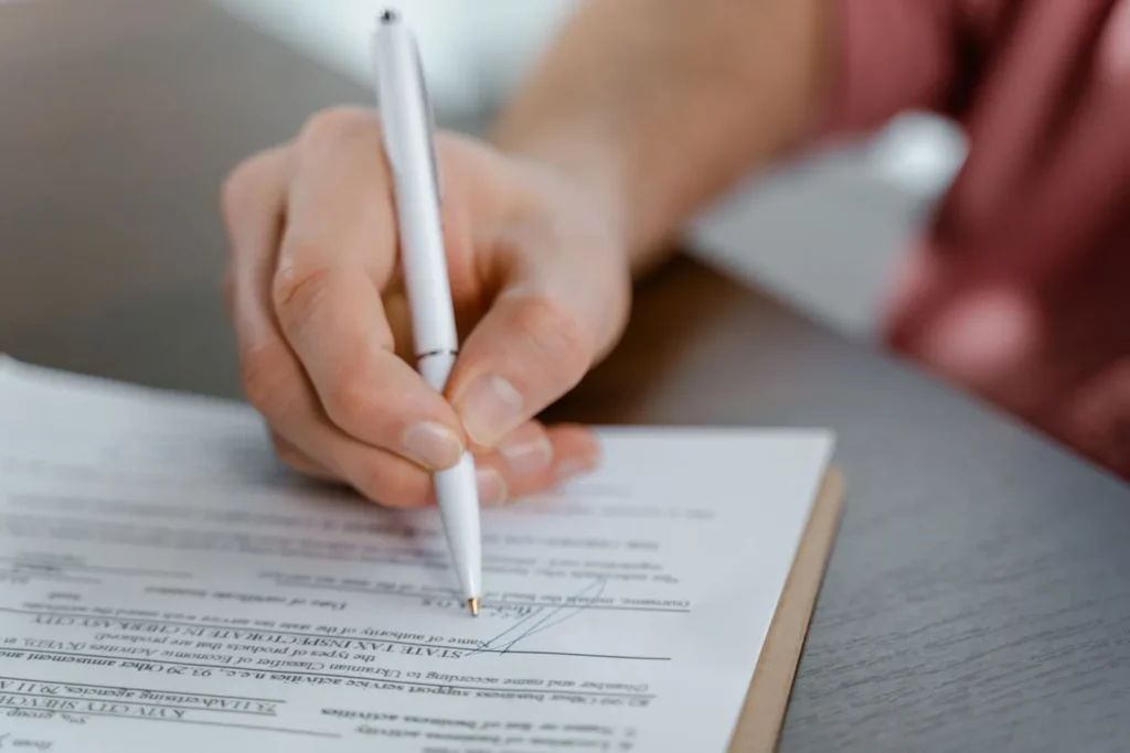 Persona firmando un documento con bolígrafo